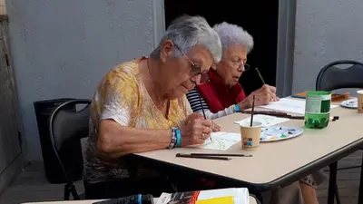 Deux personnes âgées dessinant au pinceau